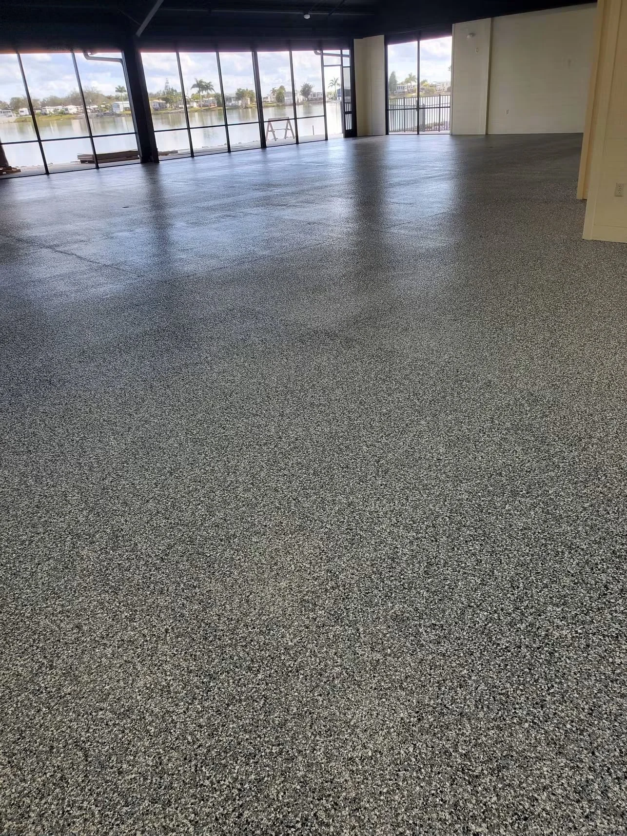 Polished concrete floor with exposed aggregate in commercial space with large windows