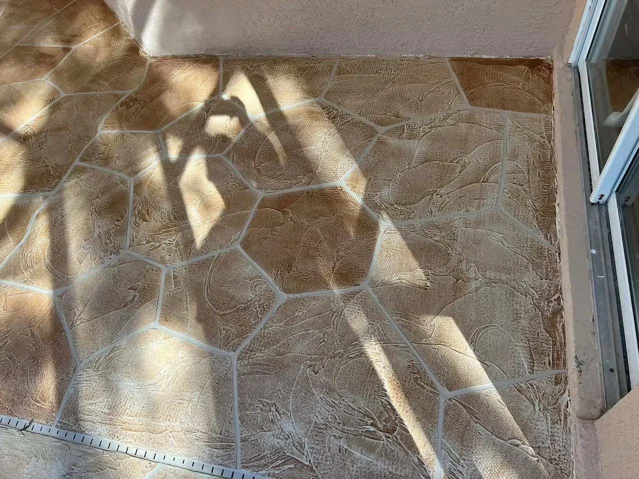 Decorative concrete patio with stone pattern and gray grout lines
