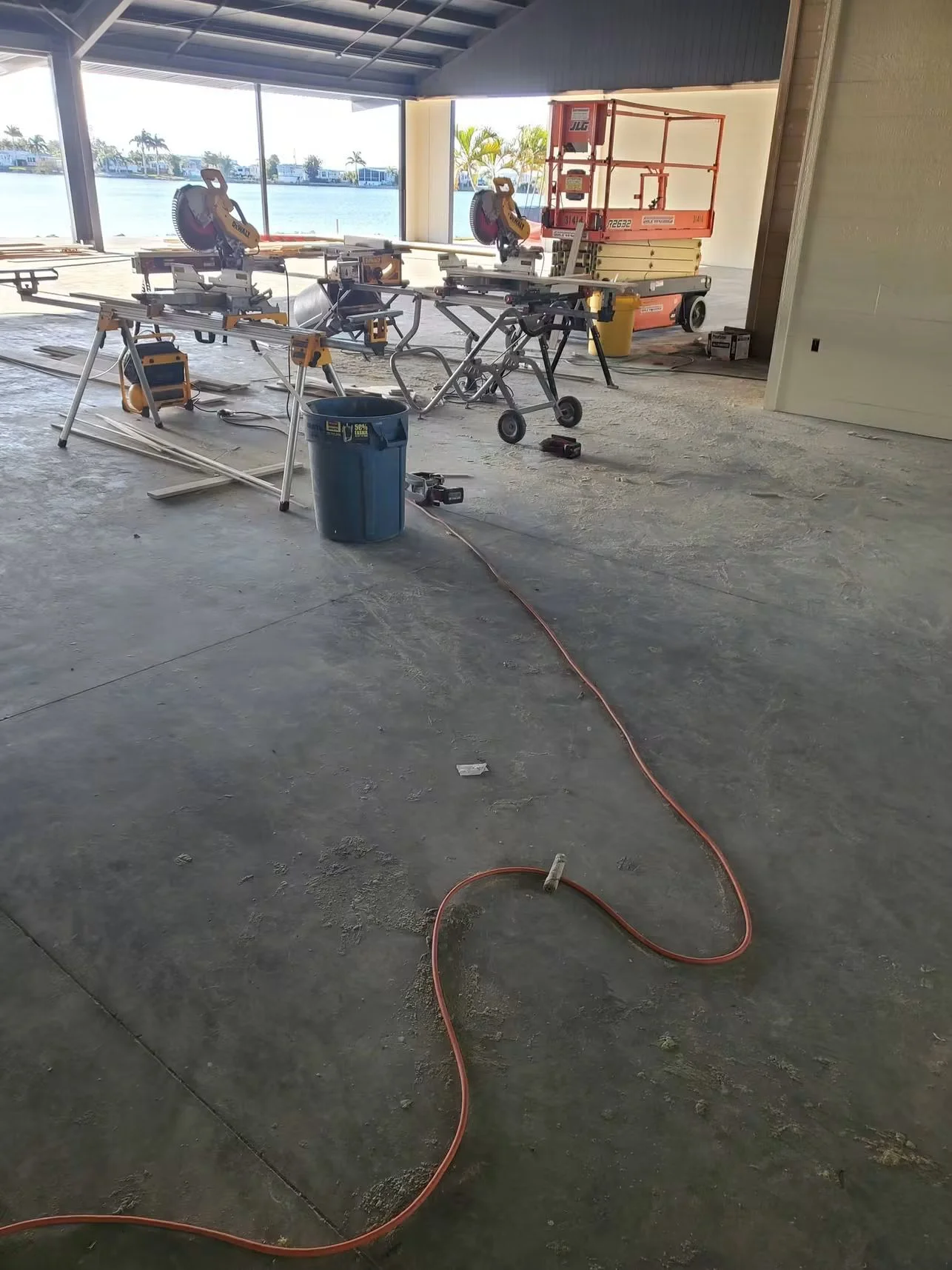 Concrete slab with power tools, finishing equipment, and work stations during active concrete contractor operations