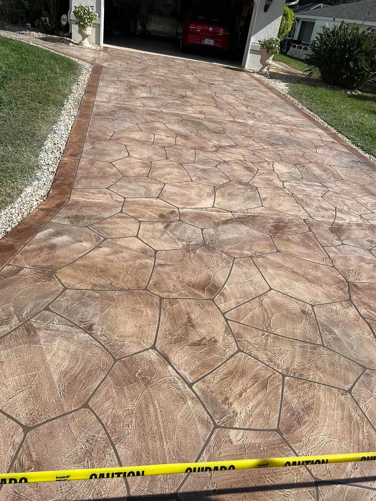 Stamped concrete driveway with stone pattern and wood-grain texture, decorative joints and border